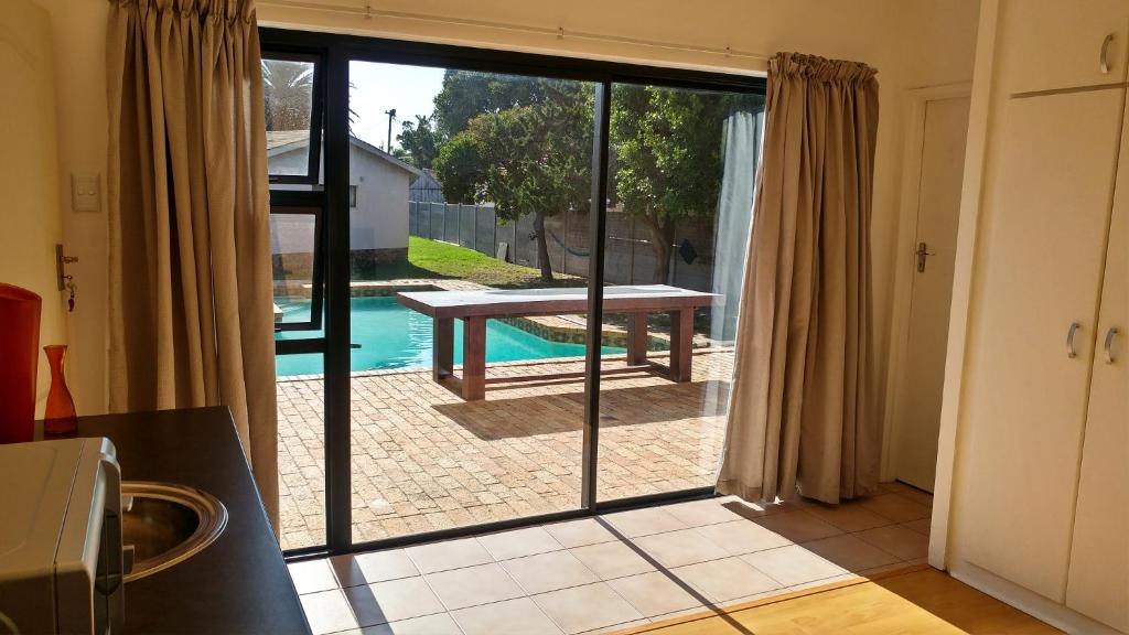 Sunlit patio and swimming pool at Blouberg Beach Retreat